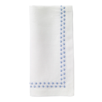 The Bodrum Pearls Napkin Ice Blue Set of 4 features off-white linen napkins with light blue embroidered dots forming an L-shaped border along two edges near the corner.