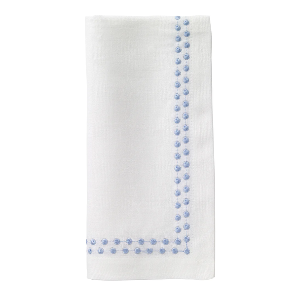 The Bodrum Pearls Napkin Ice Blue Set of 4 features off-white linen napkins with light blue embroidered dots forming an L-shaped border along two edges near the corner.