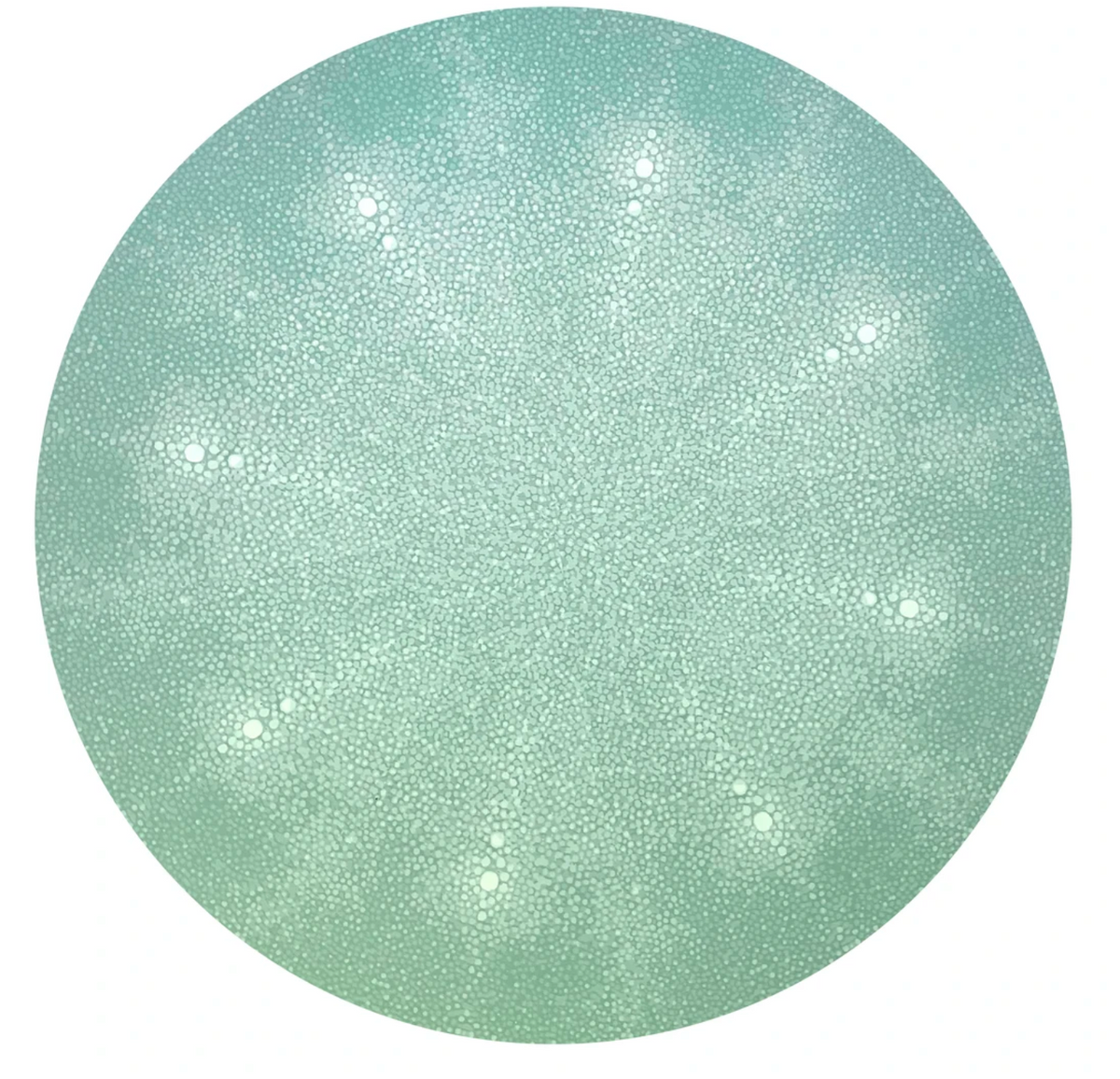 The Shagreen Placemat by Tisch New York features a circular, pale green textured pattern with small white spots and a radiating dotted surface, evoking the look of a sea urchin shell in a striking, symmetrical design.
