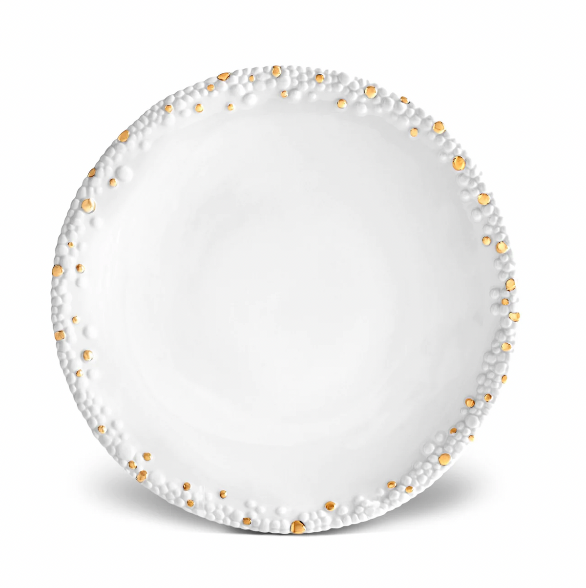 The Haas Mojave Dinnerware Gold by L'Objet is a round white fine porcelain plate featuring a textured rim with raised bumps and shiny gold dots, while the smooth center adds an elegant touch.