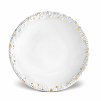 The Haas Mojave Dinnerware Gold by L'Objet is a round white fine porcelain plate featuring a textured rim with raised bumps and shiny gold dots, while the smooth center adds an elegant touch.