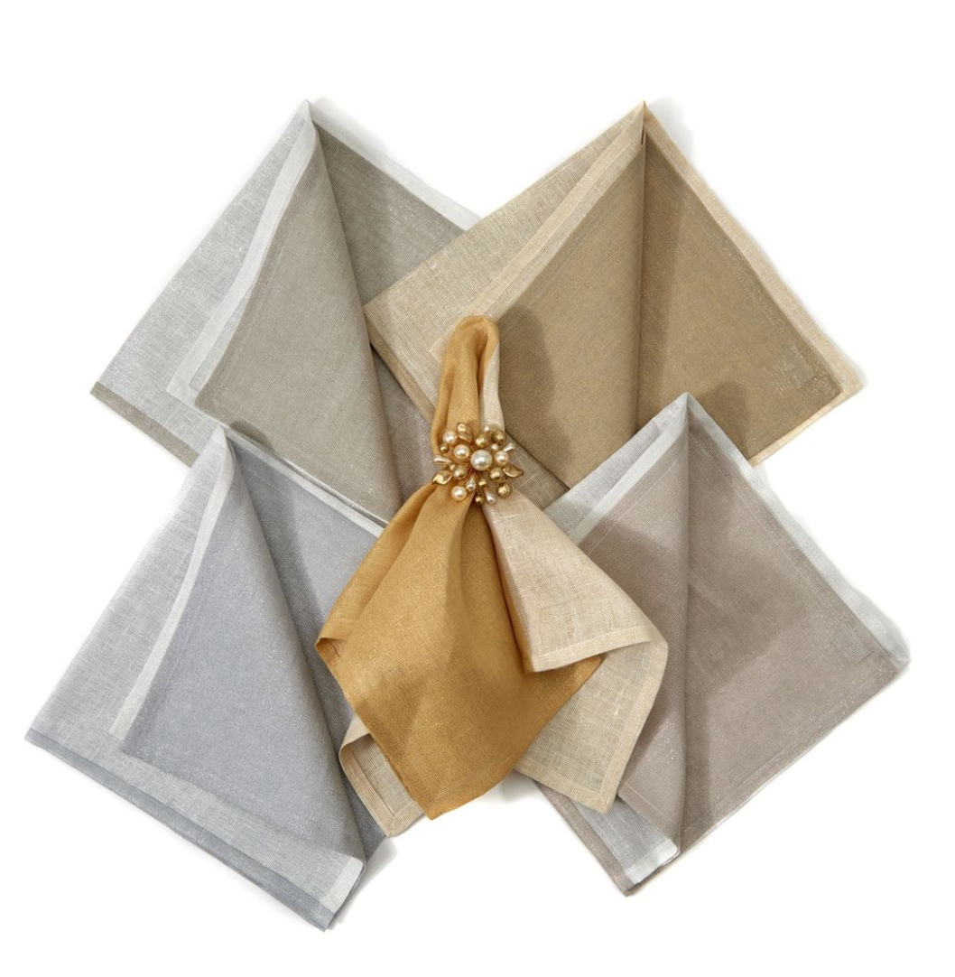 Four metallic two-tone silver napkins from Deborah Rhodes are arranged in a fan shape on a white background, each featuring an elegant pearl and gold-beaded napkin ring for a touch of shine.