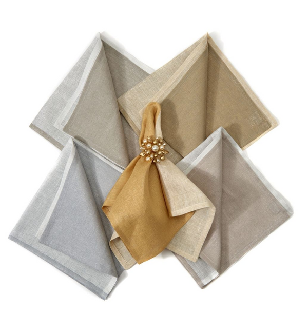 Four metallic two-tone silver napkins from Deborah Rhodes are arranged in a fan shape on a white background, each featuring an elegant pearl and gold-beaded napkin ring for a touch of shine.