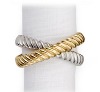 The Deco Twist Napkin Ring Set of 4 by L'Objet features two-tone rings with intertwined 24K gold plated and silver rope-like bands, displayed upright on a white textured cloth.