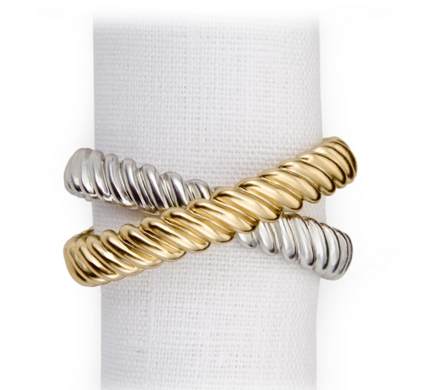 The Deco Twist Napkin Ring Set of 4 by L'Objet features two-tone rings with intertwined 24K gold plated and silver rope-like bands, displayed upright on a white textured cloth.