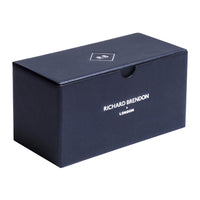 A rectangular, dark blue Richard Brendon box with white branding on the front and a small lid logo features a semi-circular cutout—ideal for presenting the Diamond Shot Glass Set of 2.