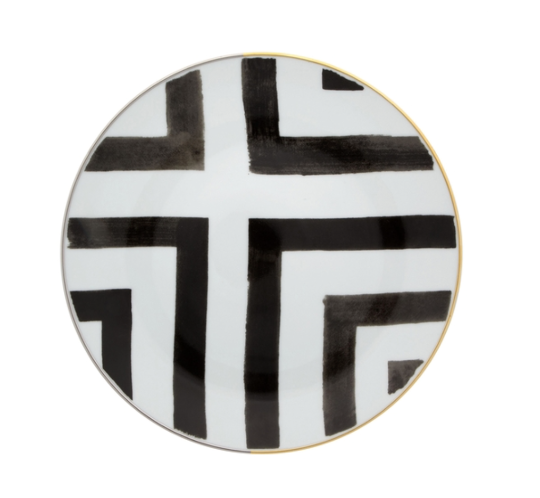 The Sol Y Sombra charger by Christian Lacroix x Vista Alegre features bold black geometric lines and a thin gold rim on round white porcelain, part of the Vista Alegre collection.