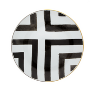 The Sol Y Sombra charger by Christian Lacroix x Vista Alegre features bold black geometric lines and a thin gold rim on round white porcelain, part of the Vista Alegre collection.