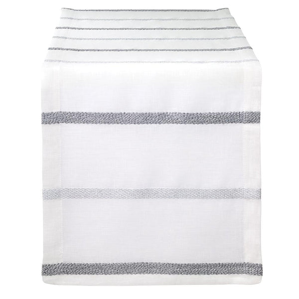 The Bodrum Metallic Band Silver Table Runner features a sleek, minimalist design with metallic silver bands, elegantly draped over the edge of a table.