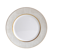 The Sauvage Gold Dinnerware by Bernardaud is a white Limoges porcelain plate featuring an embossed snake skin–textured rim and a thin gold band near the inner edge, shown from above on a white background.