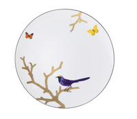The Bernardaud Aux Oiseaux Dinnerware features a white Limoges porcelain plate adorned with a gold tree branch, a purple bird perched on it, and two butterflies—one yellow and one orange—decorating the edge.