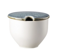 The Rosenthal Junto Aquamarine Dinnerware features a white ceramic container with a rounded base and blue-gray lid with a notched rim—ideal for holding a spoon and complementing your stoneware collection.