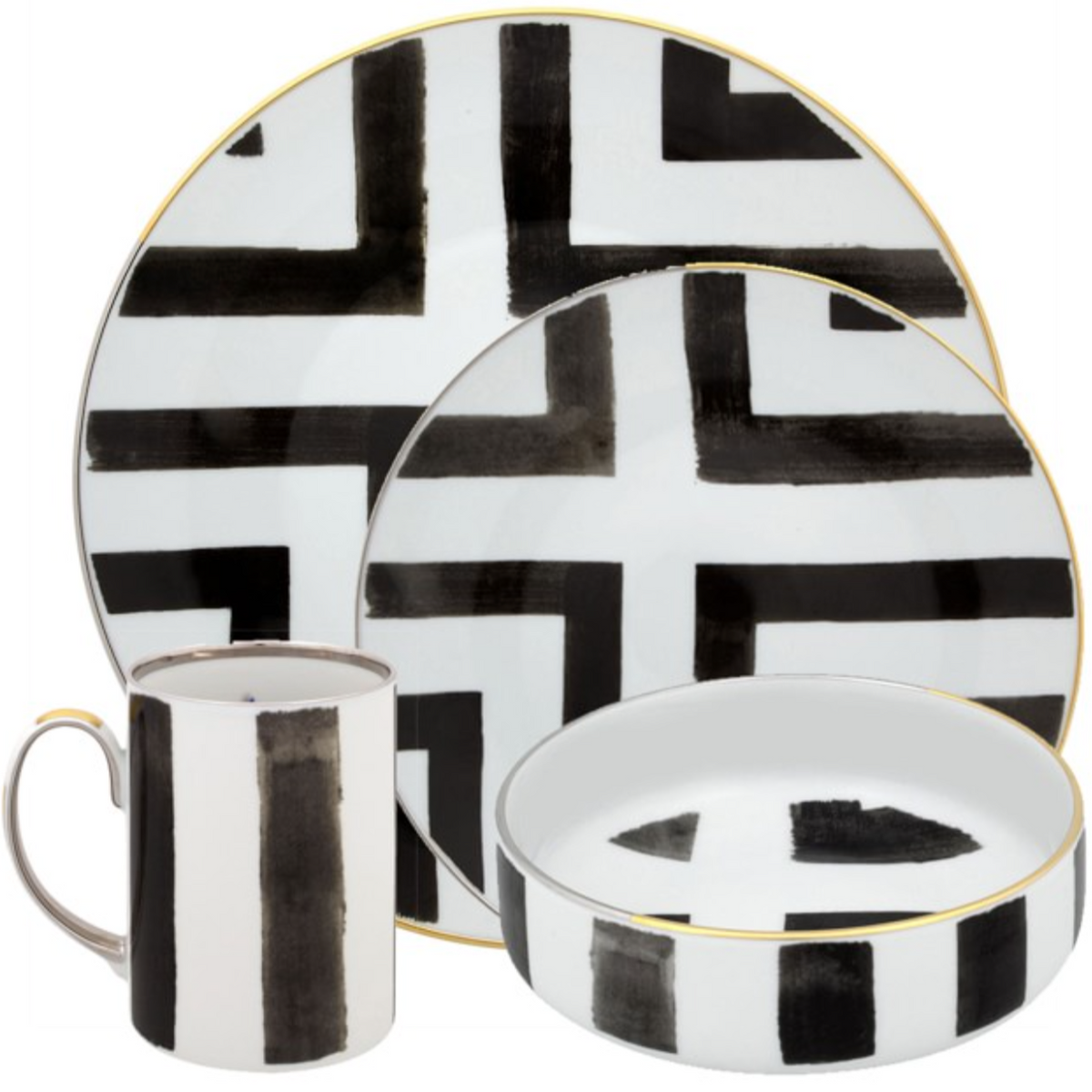 The Sol Y Sombra set by Christian Lacroix x Vista Alegre features ceramic plates, bowl, and mug with bold black geometric brushstrokes on white backgrounds and gold rims—showcasing modern Vista Alegre flair.