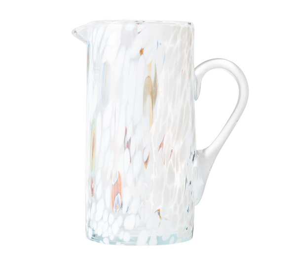 The Kim Seybert Gala Pitcher White is a tall, clear pitcher with a side handle, featuring a white, textured speckled pattern and subtle color accents that highlight the elegance of Murano-style glass.