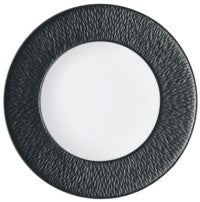 The Raynaud Mineral Irise Dinnerware - Black features a round plate with a sleek white Limoges porcelain center and a broad, textured black rim—ideal for modern dining settings.