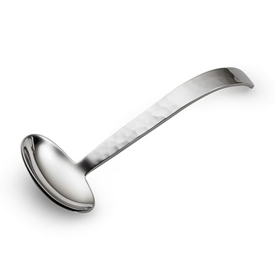 The Mary Jurek Valencia Gravy Ladle is a handmade stainless steel utensil featuring a rounded, deep bowl and a slightly curved handle, shown against a plain white background.