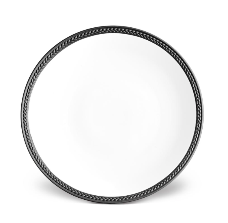 The Soie Tressée Black Dinnerware by L'Objet features a round white porcelain plate with a black braided rim—a sophisticated touch that elevates any table setting.