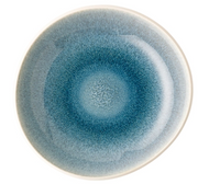 The Rosenthal Junto Aquamarine Dinnerware features a round stoneware plate with a blue gradient reactive glaze that radiates from the center to a lighter, glossy off-white rim. Microwave and dishwasher safe. Set against a white background.