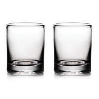 Two empty Ascutney Whiskey glasses by Simon Pearce are placed side by side on a white background.