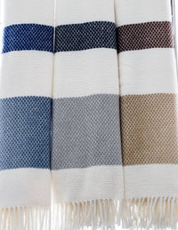 Four A Soft Idea Personalized Throw Blankets hang side by side, each with thick blue, dark brown, gray, and beige stripes on white and fringed edges—perfect custom throws to add a unique touch to your space.