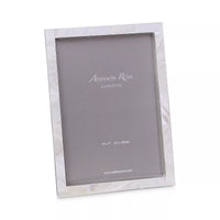 The Addison Ross Mother of Pearl Frame features a silver shell finish and holds a 5x7 inch (13x18 cm) photo. Shown with a placeholder insert, this elegant gift is photographed on a white background.