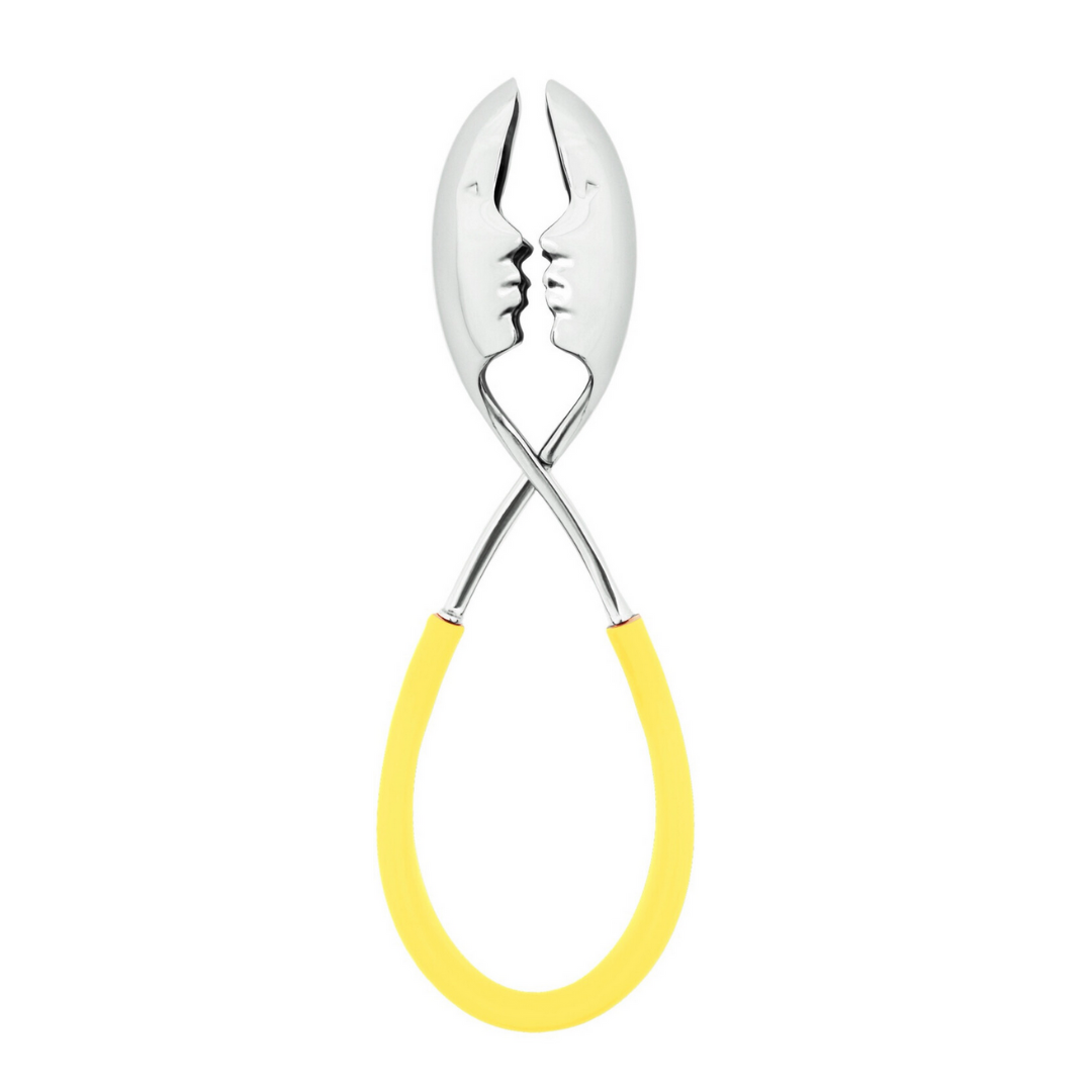 The Casa Bugatti KISS Salad Tong pairs two metal spoons with yellow handles, their heads forming face profiles about to kiss—a unique and stylish accessory for summer entertaining.