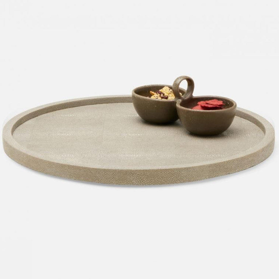 The Blue Pheasant Calvin Faux Shagreen Lazy Susan in Sand serves as a chic centerpiece, elegantly displaying two small brown snack bowls against a clean white background.