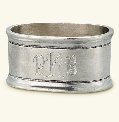 The MATCH Oval Napkin Ring Set of Two by MATCH features elegant monogram-style engraving and double-line borders, offering a timeless pewter look inspired by classic handmade designs.