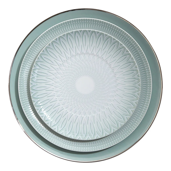 Two round plates from the Vista Alegre Venezia Dinnerware collection nest together: the smaller plate features a geometric design, while the larger showcases a solid rim with a metallic edge, all in light blue-green porcelain.