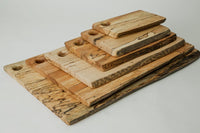 The Peterman Spalted Maple Live Edge Board 21" features unique grain patterns and a round hole in one corner, showcased on a white background.