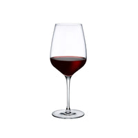 A Refine Glassware Set of 2 by Nude Glassware, filled with red wine, rests on a white background—highlighting the elegance of this delicate glassware.