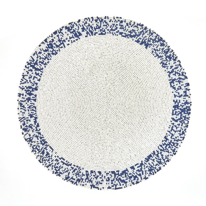 The Von Gern Home Splatter Beaded Placemat Set of 4 features round mats with a white center and pixelated blue-and-white beaded border, adding stylish decorative flair to your table.