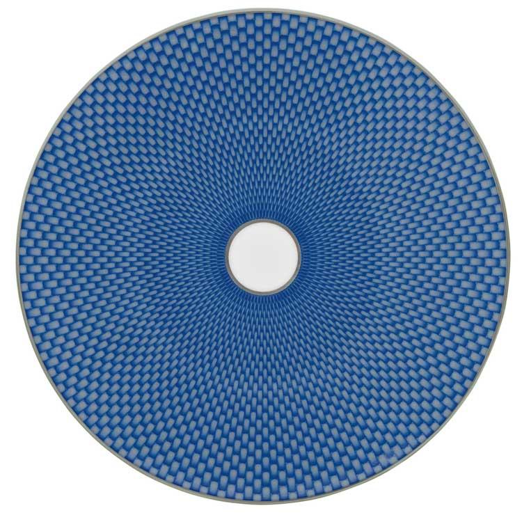 The Tresor Dinnerware Blue round plate by Raynaud features a blue geometric woven pattern radiating from a white center, with a thin white edge that enhances its formal elegance.